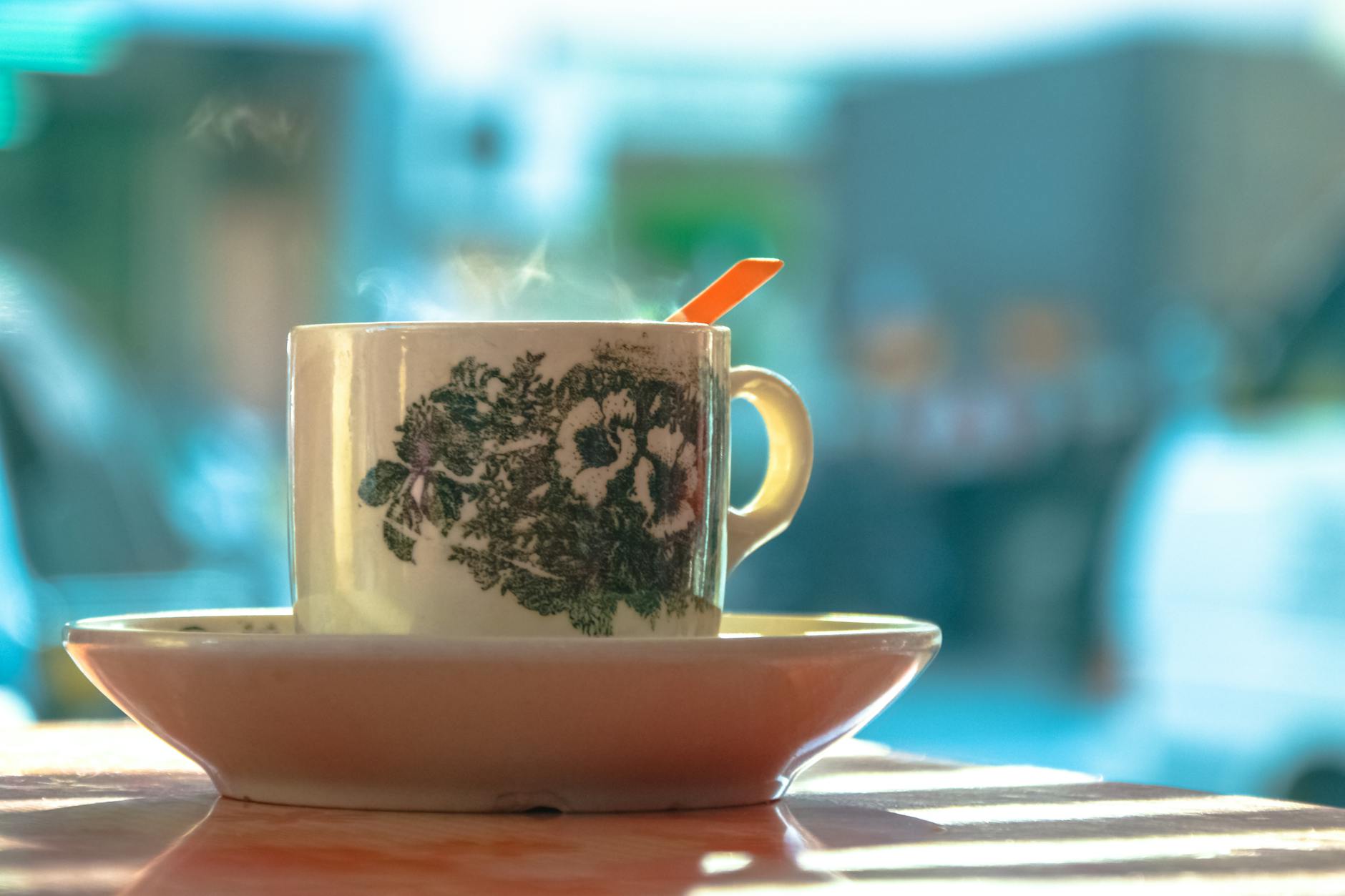 white and green ceramic mug on white ceramic plate